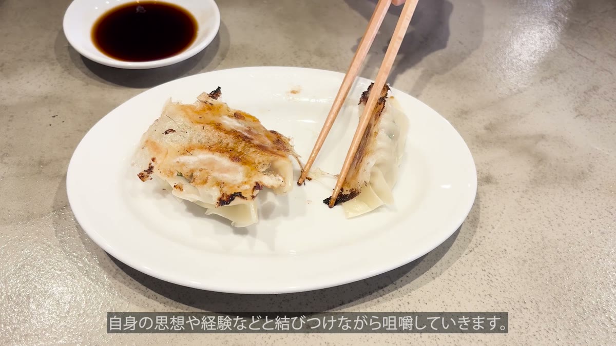 餃子をタレにつけて咀嚼する場面